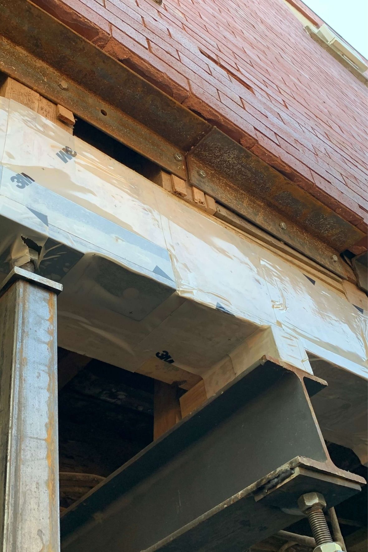 Structure métallique visible sous un bâtiment lors de travaux de soutien et de renforcement en environnement résidentiel  à Rosemont – Petite-Patrie